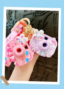 Detailed view of cute happy rabbit projection camera keychain pendants in pink and purple