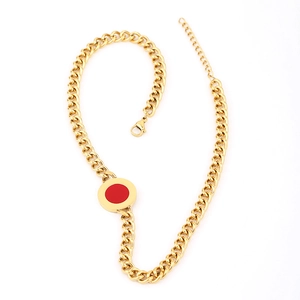 Detailed view of gold Cuban chain necklace featuring a red circular pendant and lobster clasp