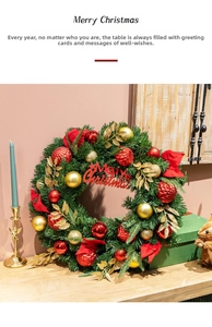 Close-up of a dense Christmas wreath with red ornaments and Merry Christmas sign