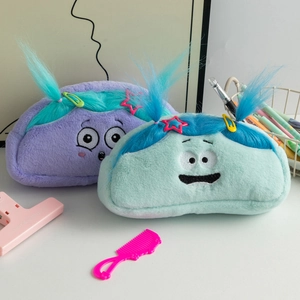 Detail of plush pencil cases with funny hair and embroidered faces in purple and cyan