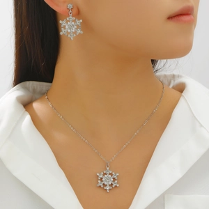 Close-up of sparkling rhinestone snowflake necklace and pearl earrings on a model