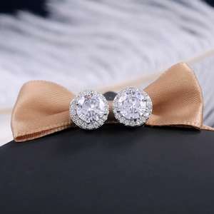 Macro detail of round cubic zirconia stud earrings with halo setting on champagne ribbon