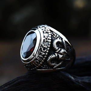 Macro detail of gothic stainless steel ring with red zircon and baphomet ram relief