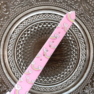 Detailed view of pink silicone watch strap featuring colorful rainbow and cloud prints