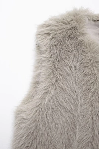 Detail of light gray faux fur vest showing soft texture and premium lining quality
