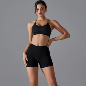 Detail of black seamless sports bra and high-waist shorts set with cross-back design