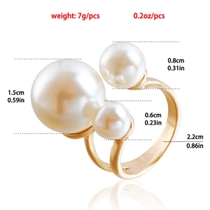 Golden open ring featuring three white faux pearls in various sizes on a white background