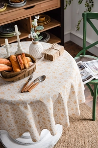 Detailed view of white Christmas tablecloth featuring golden snowflakes and bells pattern