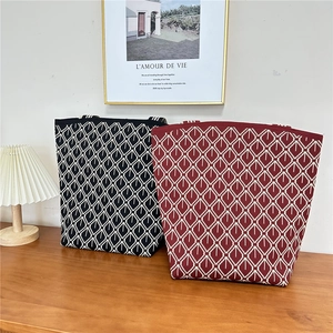 Detail of knitted tote bags with white geometric patterns in black and burgundy