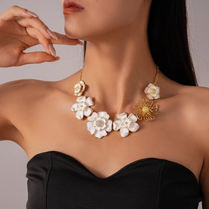 Detail of floral choker with white enamel petals and gold geometric hollow charms