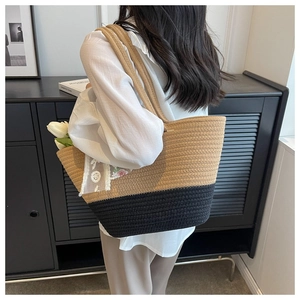 Close-up of woven tote bag with contrast stitching and delicate white lace floral applique