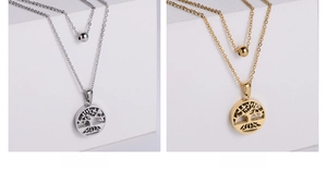 Two-layer tree of life necklaces in silver and gold finishes shown on white display stands