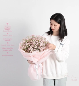 Pink artificial babys breath bouquet with decorative ribbon and translucent wrapping paper