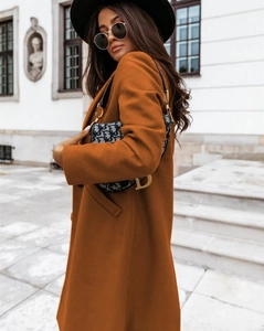 Macro view of caramel wool coat texture and lapel details in a street style setting