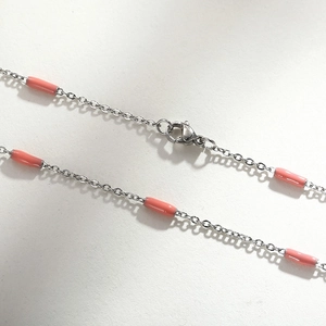 Detail of 1.5mm titanium chain necklace with pink beads and a secure lobster clasp