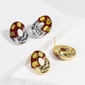 Macro detail of French vintage red enamel oval earrings on white stone background
