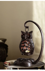 Vue détaillée du bougeoir hibou en fonte vintage avec des motifs creux raffinés