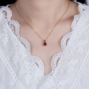 Close-up of 925 sterling silver necklace featuring a faceted red zircon pendant on a model