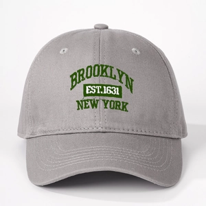 Detailed close-up of dark green Brooklyn New York embroidery on a grey cotton baseball cap