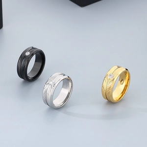 Polished stainless steel feather rings with cubic zirconia in gold, silver, and black