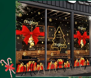 Close-up of golden Christmas window stickers with red bow on coffee shop glass