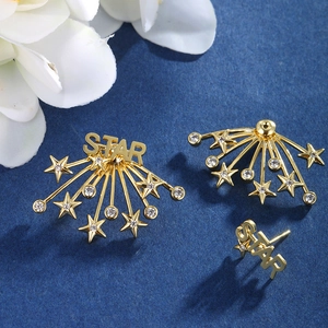 Macro shot of gold star stud earrings with zircon inlay and STAR letter pendant