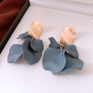 Detailed view of matte blue floral petal earrings with gold metallic texture in jewelry box