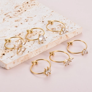 Vista dettagliata di sei earcuff dorati con zirconi trasparenti e motivi floreali