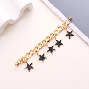 Detailed view of a gold-plated chunky chain featuring black enamel star charms and magnetic clasp