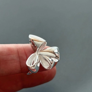 Detailed view of S925 silver bow-knot ring with a polished finish worn on finger