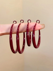 Close-up of wine red enamel hoop earrings in two sizes showing high glossy finish
