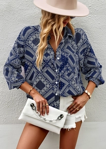Detail of vintage navy blue printed long sleeve blouse paired with denim shorts and a white bag