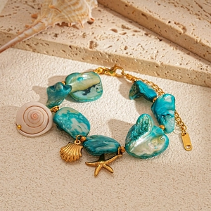 Detail of beach style necklace featuring blue stone beads, golden starfish and shell charms