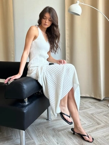 Detail of white V-neck ribbed knit maxi dress showing the stretch texture and drape
