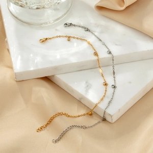 Minimalist gold and silver bracelets with diamond accents on marble and silk surface