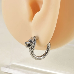 Antique silver wolf head hoop earring with detailed scale texture on a model ear