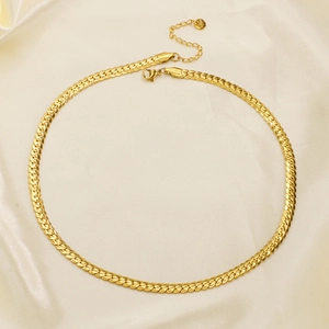 Polished gold flat snake chain necklace made of stainless steel on white silk background