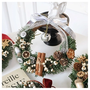 Detailed Christmas wreath with pine needles, pine cones, cinnamon sticks and metal bell