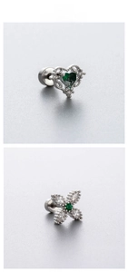 Macro shot of titanium steel heart and cross earrings with emerald green zircon detail