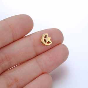 Polished stainless steel gold moon and star bead pendant held for jewelry making