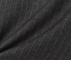 Detail of dark grey striped wool fabric showing texture and pinstripe pattern on culottes