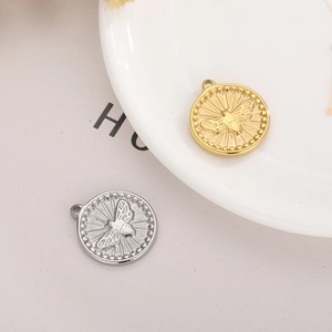 Detailed view of round bee pendant charms in gold and silver with embossed insect motif