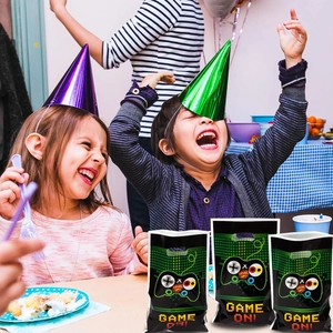 Three Game On themed party gift bags with green handles for a kids birthday celebration