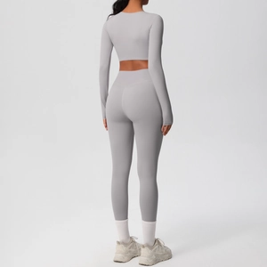 Back view of slim fit light grey seamless yoga set with long sleeve crop top and leggings