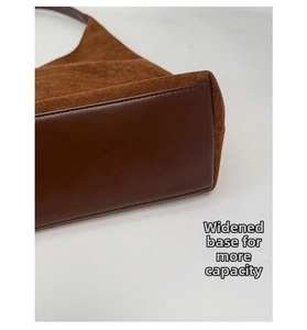 Detail of wide base and premium suede stitching on large brown tote bag