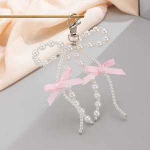 Detailed view of handmade faux pearl bow keychain with elegant pink ribbon accents