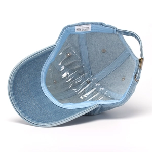 Detailed macro view of denim baseball cap interior with wash tag and metal adjuster