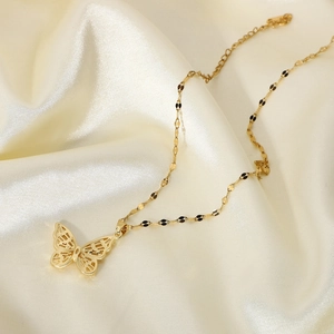 18K gold plated butterfly pendant necklace with cubic zirconia on champagne silk backdrop