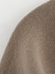 Close-up of brown knitted scarf fabric texture with soft machine knit detailing
