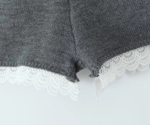 Vue détaillée du short en maille gris foncé avec bordure en dentelle blanche sur l'ourlet